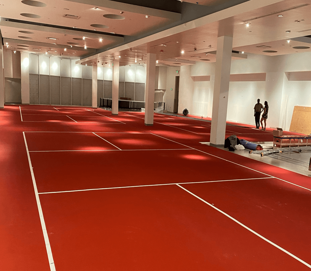 Rollout pickleball courts being installed inside a commercial building