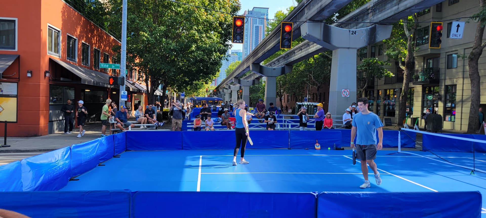 Roll-out pickleball court set up on a city street with players mid-game